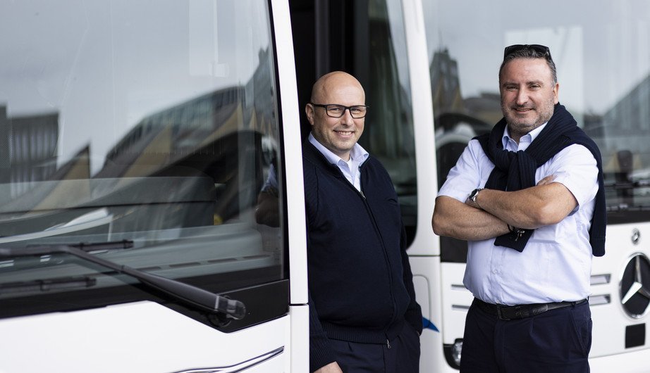 Zwei Busfahrer neben Bus