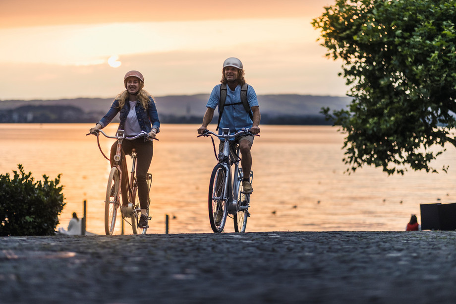 Velofahrer am Zugersee bei Sonnenuntergang Zwei Velofahrer mit See im Hintergrund in Abendstimmung