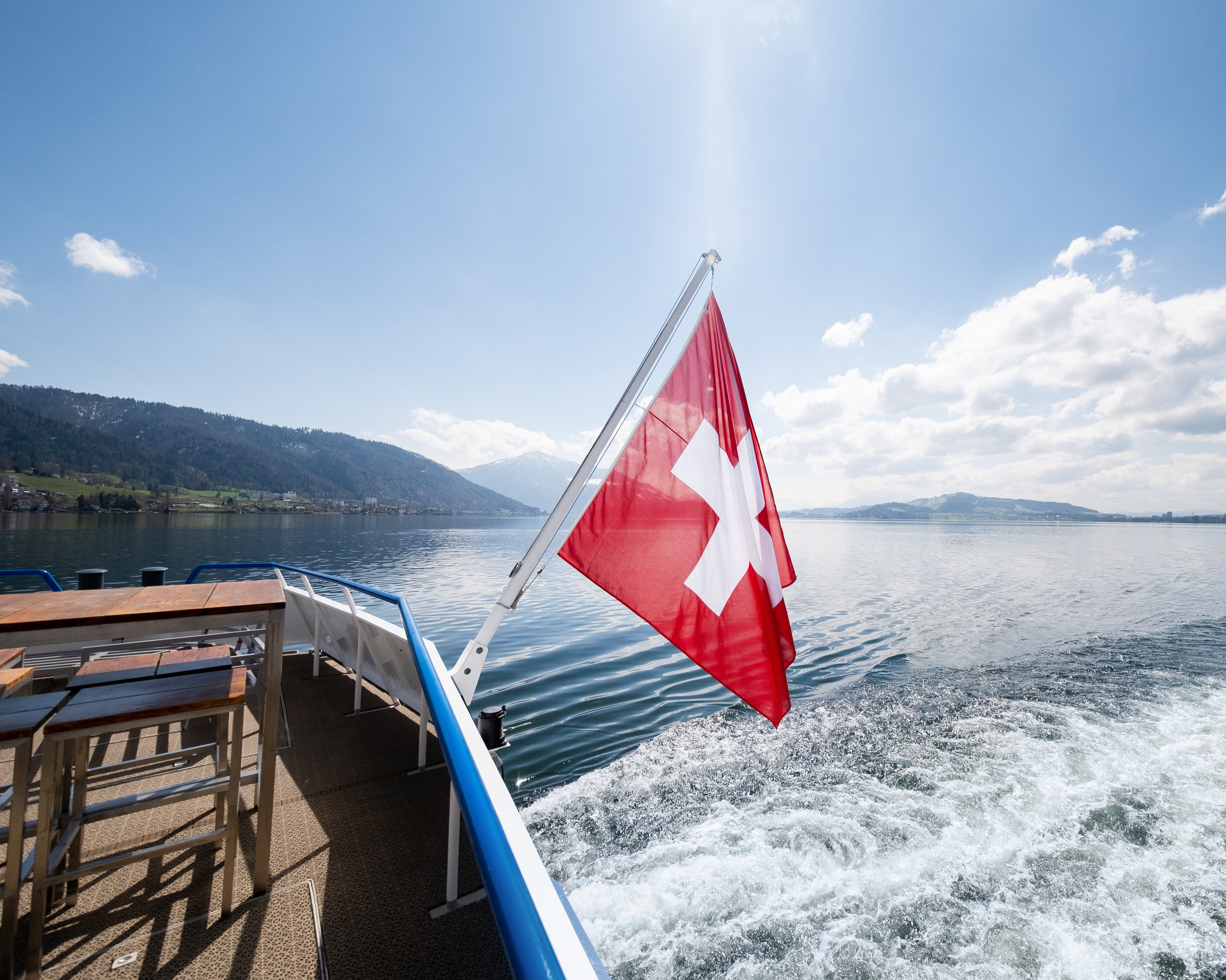 Schweizerfahne Fahne wehend am Heck mit Blick über den See