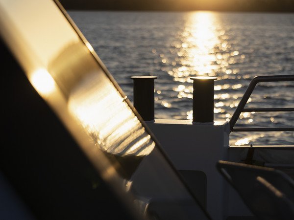 Reling im Sonnenuntergang mit glitzerndem See